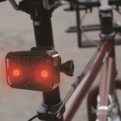 Cámara con luz trasera blanca y roja para seguridad en bicicleta.